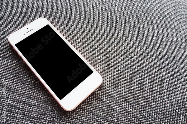 Obraz Close up phone mobile blank screen on sofa top view, mock-up new smartphone rose gold color.