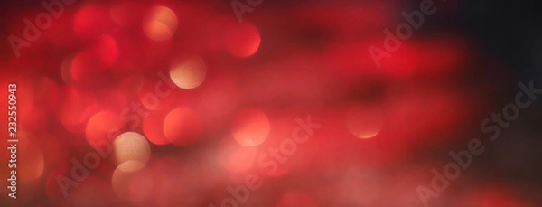Fototapeta Blurred background lights. Abstract defocused gold, white, red and yellow glitters texture on black background. Shining glowing snow effects