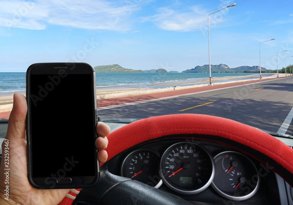 Fototapeta Man parking the car to use smartphone which blank screen, used for road safety concept.