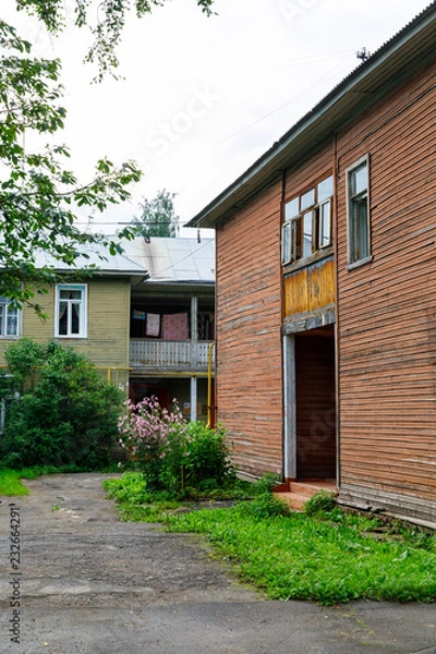 Obraz Wooden house with carved polisade in Vologda. Russian traditional architecture lies in wooden houses with manually carved decorations, often painted in white