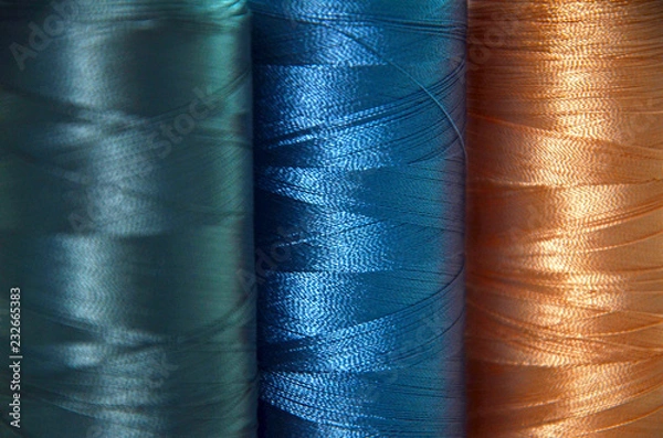 Fototapeta threads in blue colors on the background of a sewing machine