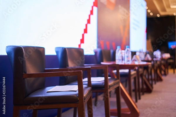 Fototapeta chairs and tables stand on the stage - there are papers on the chairs, the scene is blurred background