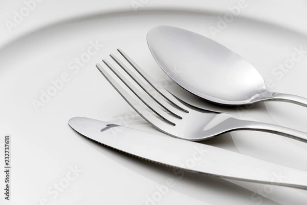Fototapeta Fork and spoon on an empty plate