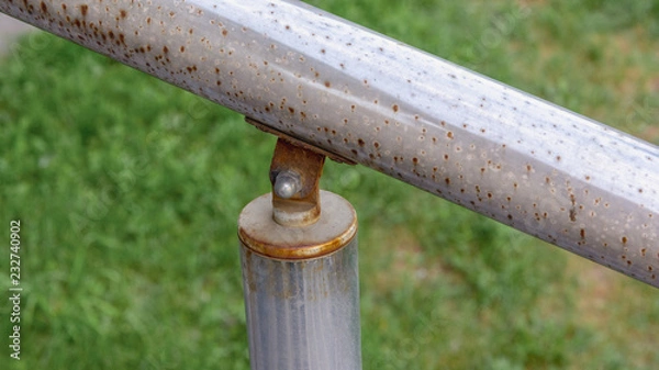 Obraz chrome rusty steel railing fixed on post on the nut