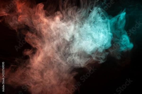 Fototapeta Multicolored smoke from a vape of green and red color of the strange mystical form on on a black isolated background. Bright clouds in the abstract form.