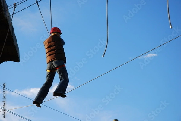 Obraz courageous woman standing on a steel wire taking a