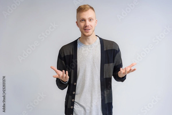 Fototapeta Studio portrait concept of a smiling young man talking on a white background.