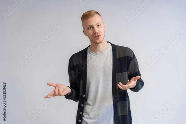 Fototapeta Studio portrait concept of a smiling young man talking on a white background.