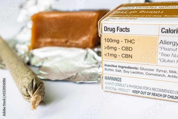 Obraz Marijuana Edible Infused Caramel Candy With Labeled Drug Facts & Marijuana Cigarette Up Close