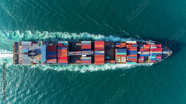 Obraz Aerial view Top speed with beautiful wave of container ship full load container with crane loading container for logistics import  export or transportation concept background.