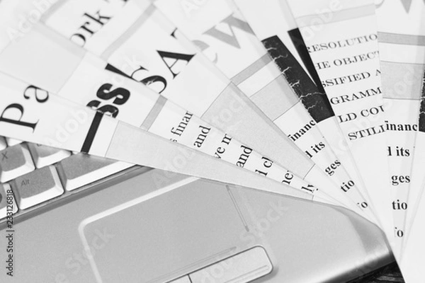 Obraz Folded newspapers with headlines and articles on keyboard of laptop. Modern technology replacing old fashioned paper journals and magazines, since internet is more fast way to get news and information