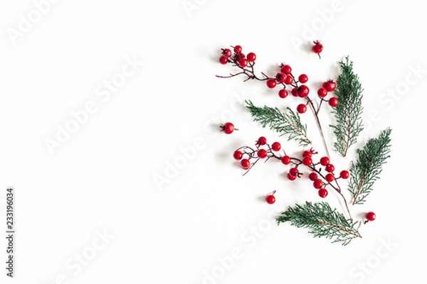 Fototapeta Christmas composition. Pattern made of fir tree branches and red berries on white background. Christmas, winter, new, year, nature concept. Flat lay, top view, copy space