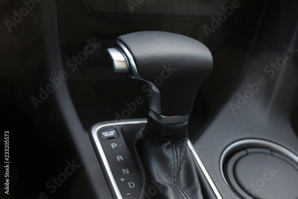 Fototapeta Car interior. Black leather automatic gearbox with chrome button and round ashtray 