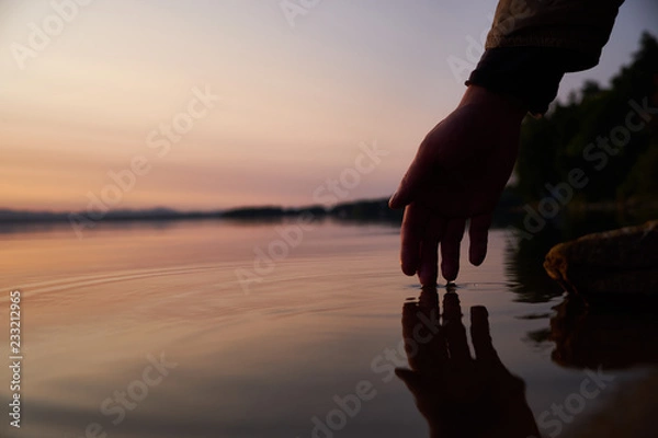 Obraz Human hand touching the fresh water from lake. Close-up. Lifestyles concept.