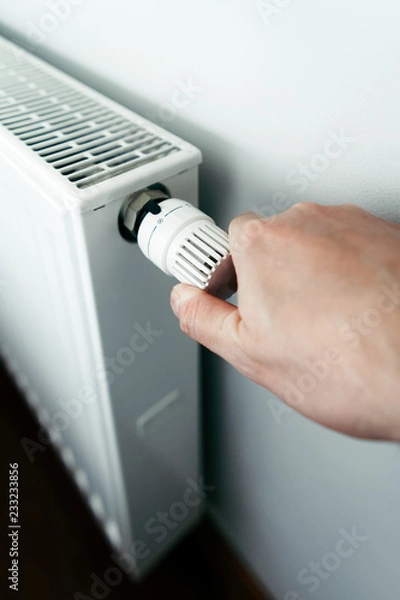 Obraz Men hand on battery temperature controller heating close up