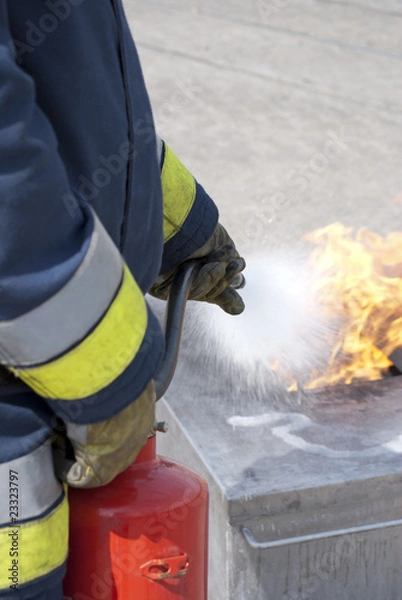 Fototapeta Firefighter using fire extinguisher