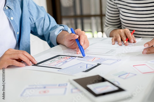 Fototapeta Creative Web Designer planning application and developing template layout, framework for mobile phone. User experience (UX) concept.