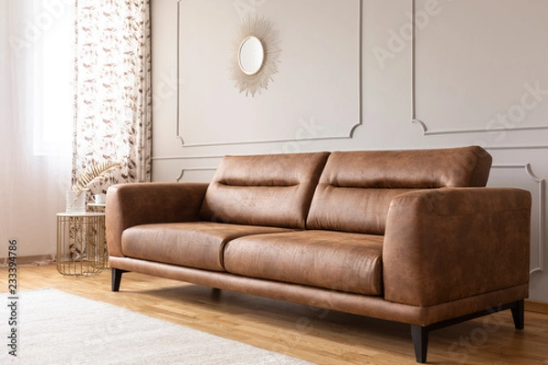 Obraz Real photo of a leather couch in a living room interior