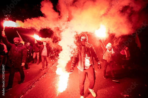 Fototapeta Ludzie noszą polskie flagi i spalają flary, gdy przechodzą przez most Poniatowski podczas marszu z okazji 100. rocznicy polskiej niepodległości w Warszawie, Polska 11 listopada 2018 r.