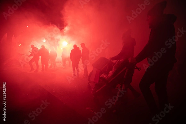 Obraz People carry Polish flags and burn flares as they walk across the Poniatowski Bridge during a march marking the 100th anniversary of Polish independence in Warsaw, Poland November 11, 2018. 
