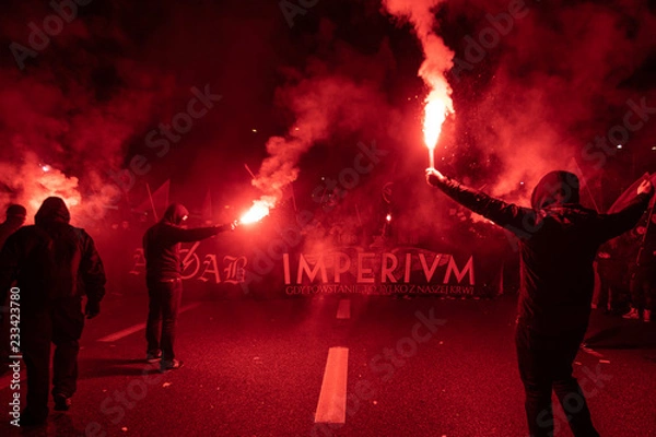 Obraz Ludzie niosą polskie flagi i palą flary, przechodząc przez Most Poniatowskiego podczas marszu z okazji 100. rocznicy odzyskania przez Polskę niepodległości w Warszawie 11 listopada 2018 r.