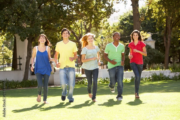 Fototapeta Group Of Teenagers Running Through Park