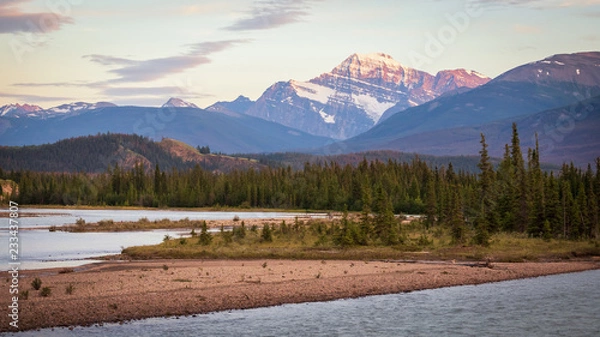 Fototapeta Snowy Mountain Peak with River and Pine Forest