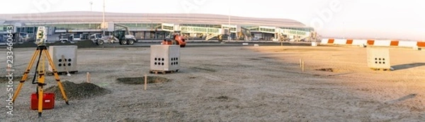 Fototapeta Panoramic view of surveyor equipment (theodolite or total positioning station) on the construction site of the building or airport
