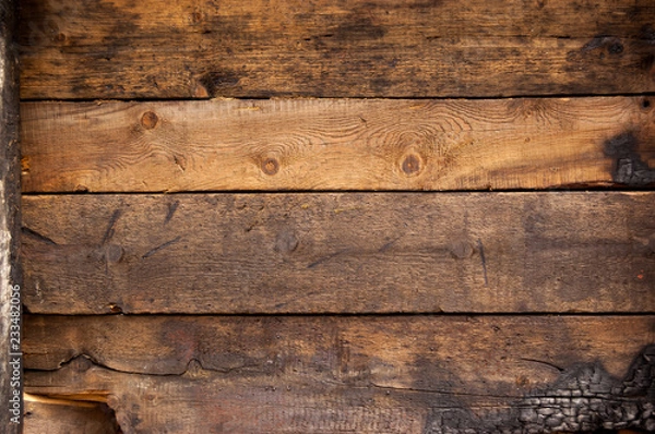 Fototapeta Black and brown burnt wall of house of wooden planks with embossed texture. background for copy space. concept of loss of real estate or home. property insurance