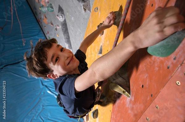 Obraz mały chłopiec wspinaczka po skalnej ścianie