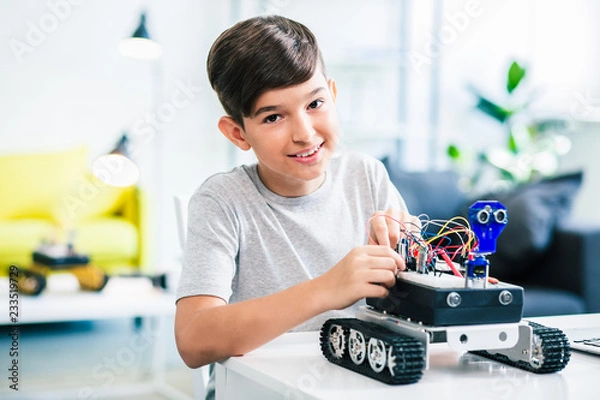 Obraz Nice smiling little boy constructing modern robot