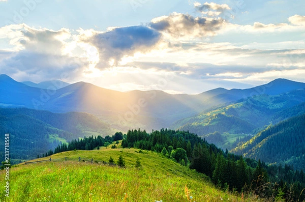 Obraz sun's rays break through the clouds in the mountains