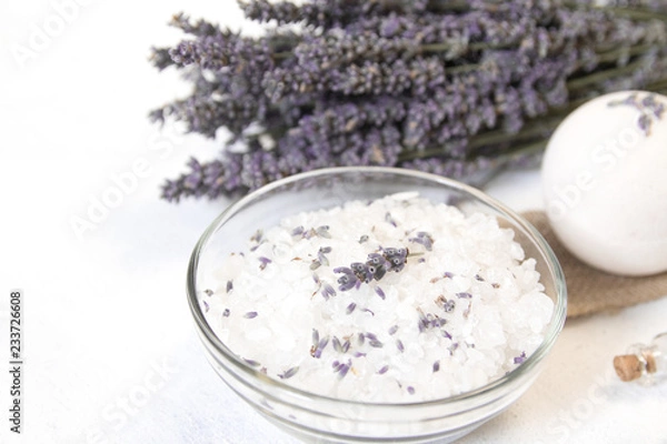 Obraz Natural herbal sea salt with aromatic lavender - perfect for relaxation. Cosmetic jars and bottles with salt, lavender flowers, bath bomb