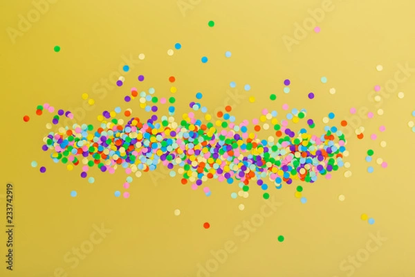 Fototapeta Kolorowe konfetti na żółtym tle.