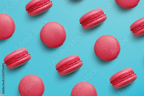 Fototapeta Macaroons on colored background, a pattern of colorful french cookies macarons. Beige, brown french cookies macarons on red background. Gift for Valentine's Day
