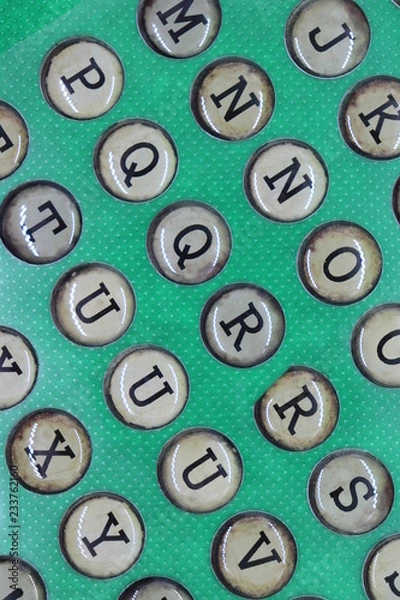 Fototapeta Retro letters in circles like typewriter keys on green background