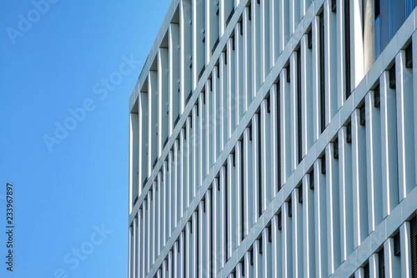 Fototapeta Fragment of a facade of a building with windows and balconies. Modern home with many flats.