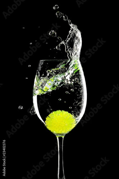 Obraz plusk w szklance z kulką cytryny na czarnym tle
