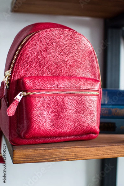 Obraz red leather backpacks on wooden bookcase shelf, womens leather backpacks, the front of the red rucksack