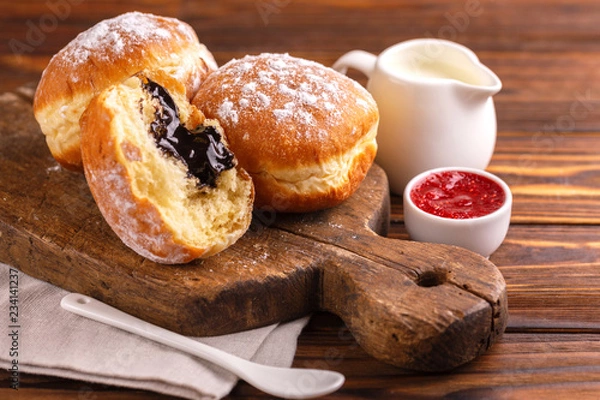 Fototapeta Tasty sweet sugary chocolate donuts with raspberry jam and milk