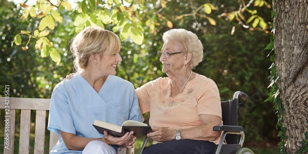 Fototapeta Opiekun czyta książkę osobie starszej