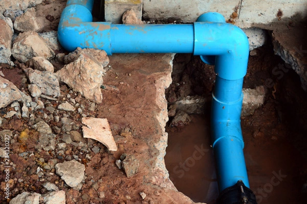 Obraz the The  blue crooked water pipe .and the traces from workers cracks the cement and digged floor to repair the water pipe system.
