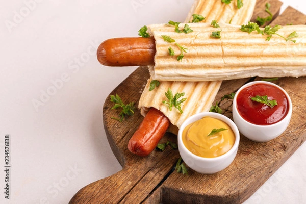 Fototapeta Two tasty grilled french hot dog with mustard and ketchup