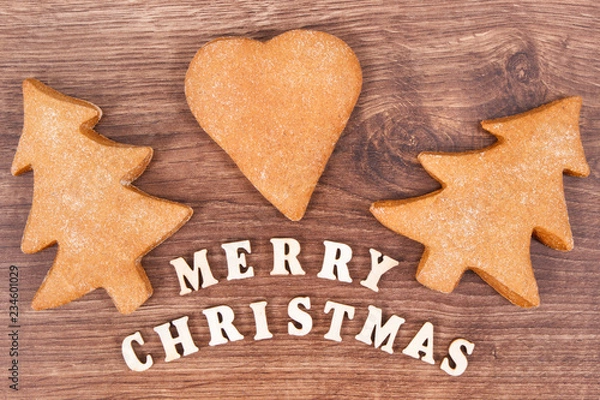 Fototapeta Inscription Merry Christmas with homemade gingerbreads and cookies for festive time