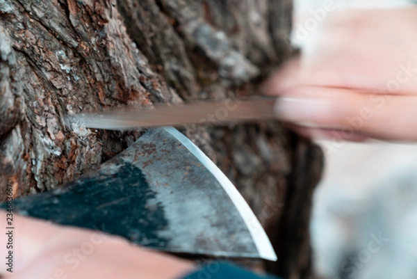 Obraz Man sharpening axe blade