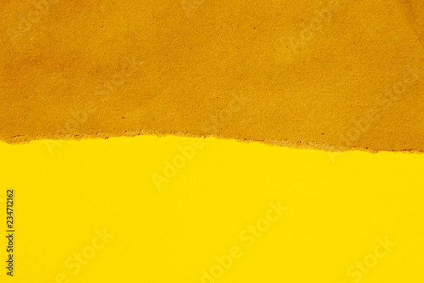 Fototapeta torn brown paper on yellow backgroung with copyspace