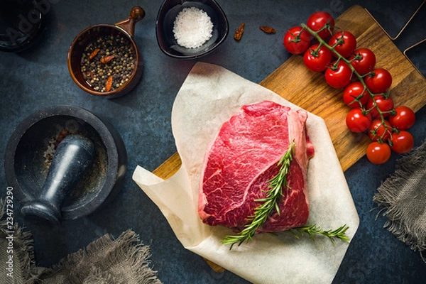 Obraz Raw Fresh Marbled Meat Beef with spices ready for cooking on a blue concrete background top view.