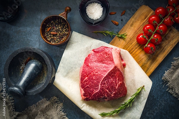 Obraz Raw Fresh Marbled Meat Beef with spices ready for cooking on a blue concrete background top view.