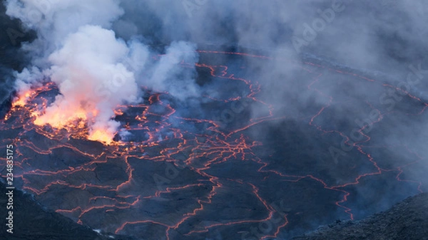 Obraz Molten magma red hot lava flowing on cold lavafiled in grey colored texture of volcanic background. Nyiragongo Volcano. RD Congo