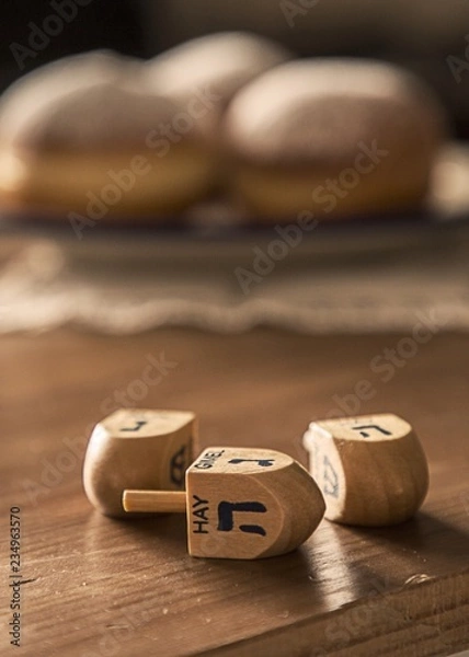 Fototapeta Hanukkah Celebration Concept-dreidels on the Rustic table with D